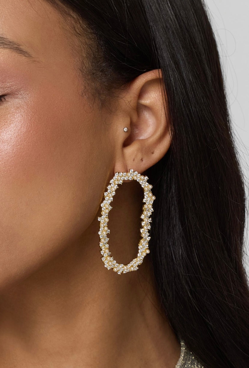 Close-up of a woman's ear wearing Kinsey Designs' Abbie Earring—gold filled large oval hoops with small crystals, ideal for those seeking elegant sample sale jewelry.