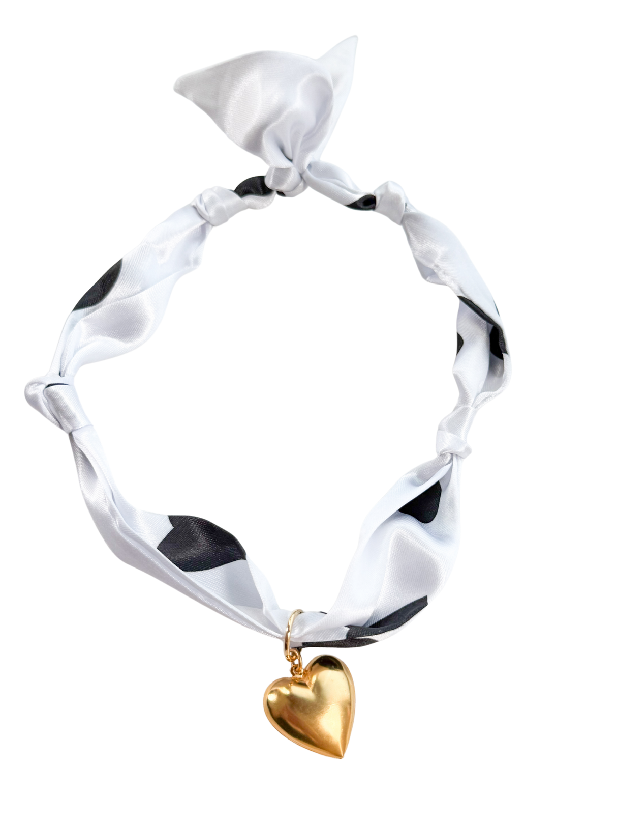 The Cagliari Scarf Necklace by Kinsey Designs is a white silk scarf with black accents, tied in a knot and finished with a gold heart charm—an adjustable, chic accessory to elevate any outfit.