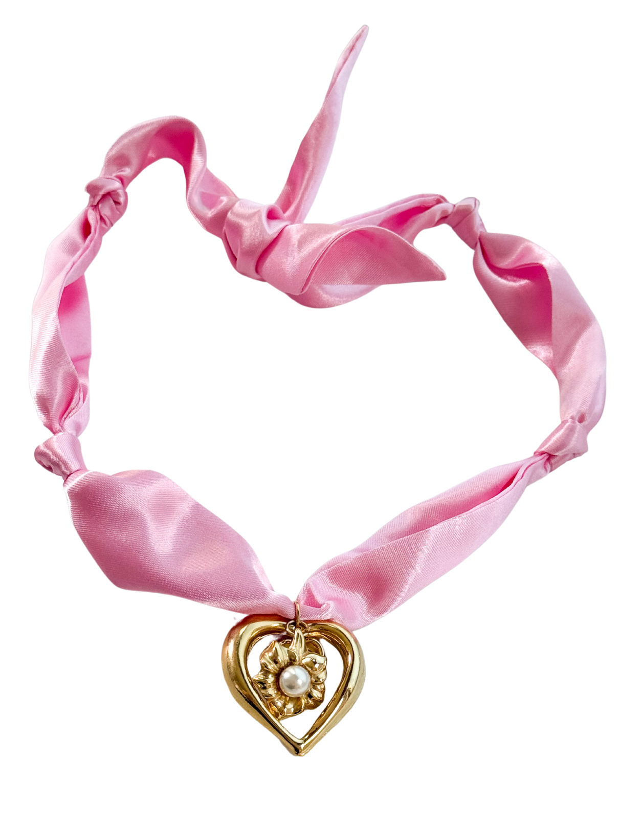 The Ancona Scarf Necklace by Kinsey Designs features a pink satin ribbon, adjustable fit, gold heart pendant, and pearl detail, shown on a white background.