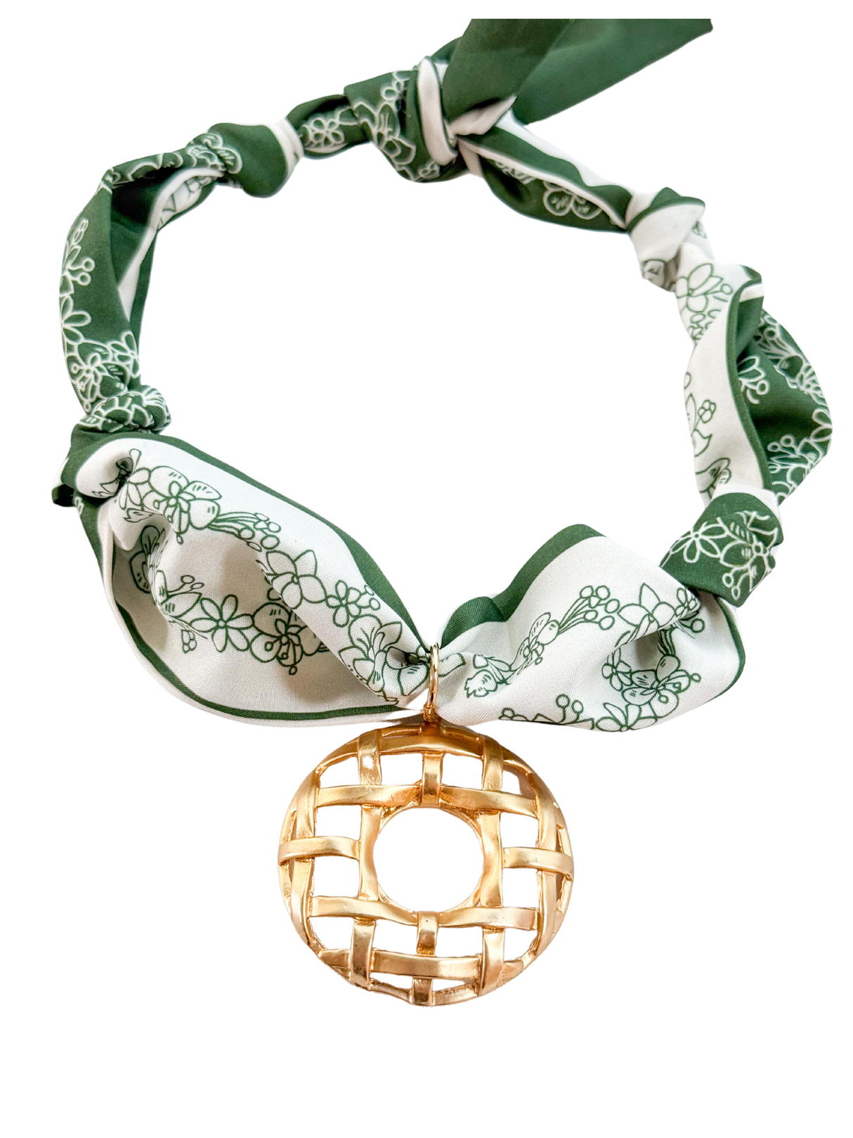 The Bari Scarf Necklace by Kinsey Designs features a green and white pattern and a large vintage-inspired gold circular pendant as its centerpiece.