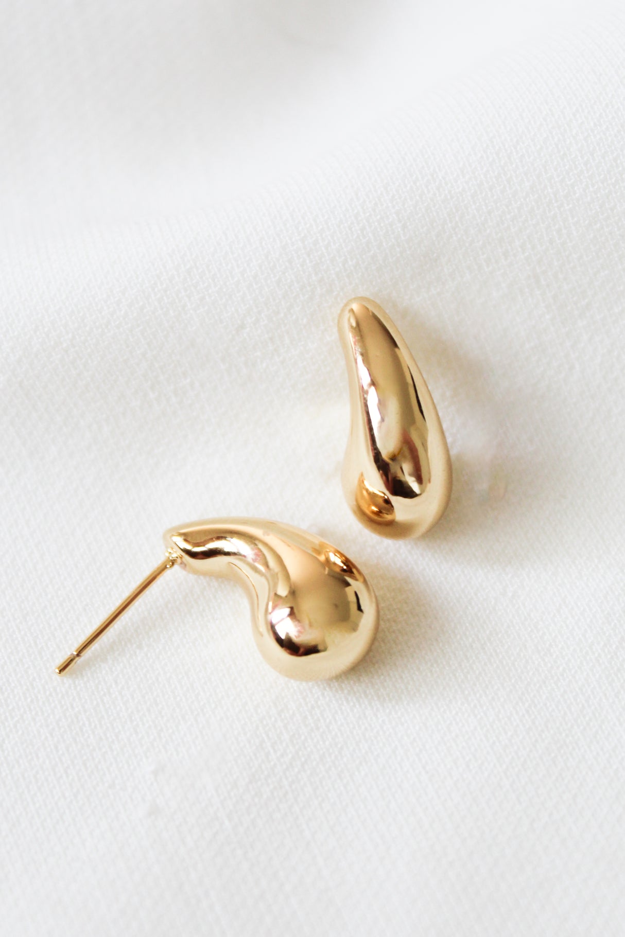 The Kinsey Designs Baby Drop Post earrings are two gold filled, abstract-shaped studs measuring .75" long, shown on a white textured fabric background.