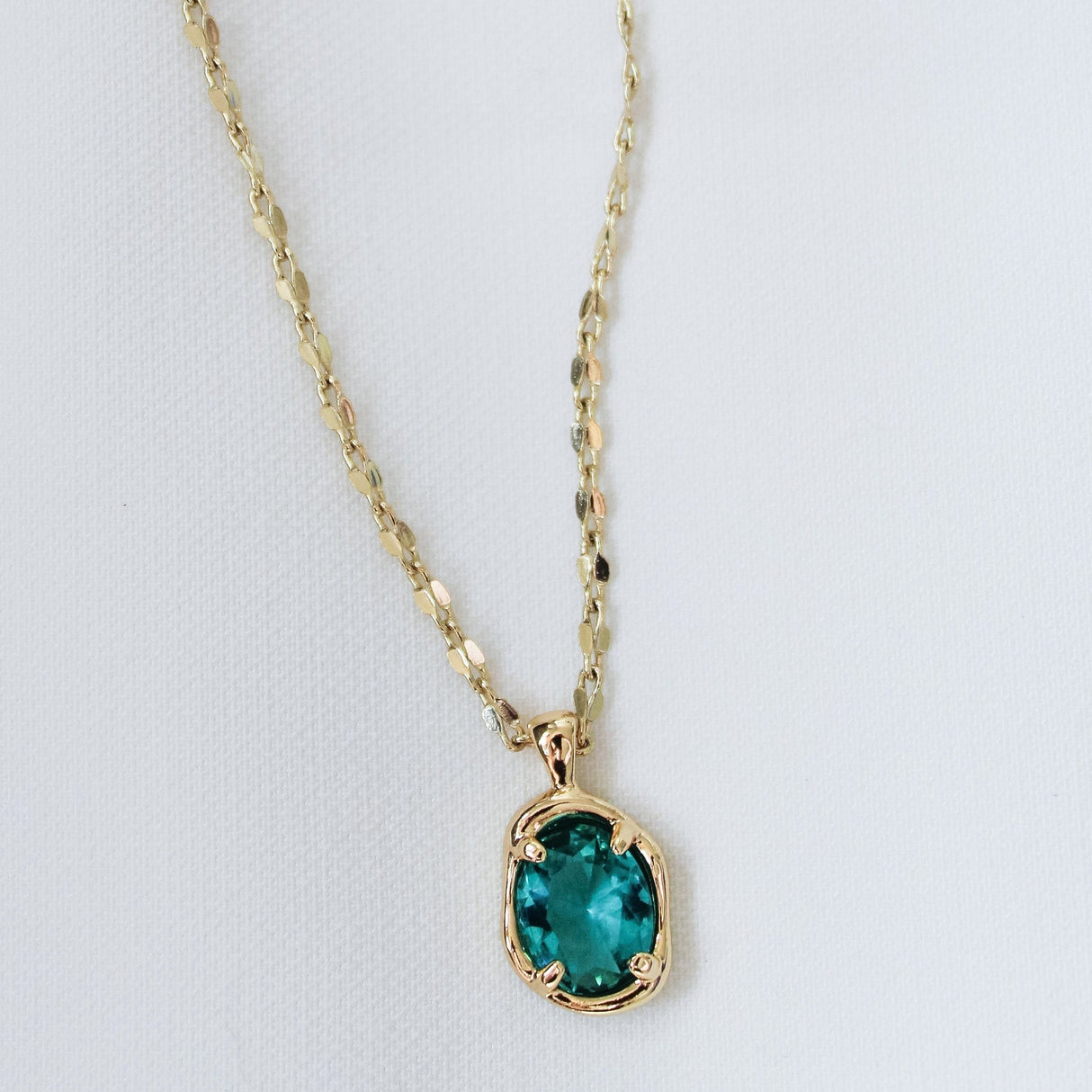 The Birdie Blue Necklace by Kinsey Designs Archives features an oval green gemstone pendant on an 18-inch gold filled chain, shown against a plain white background.