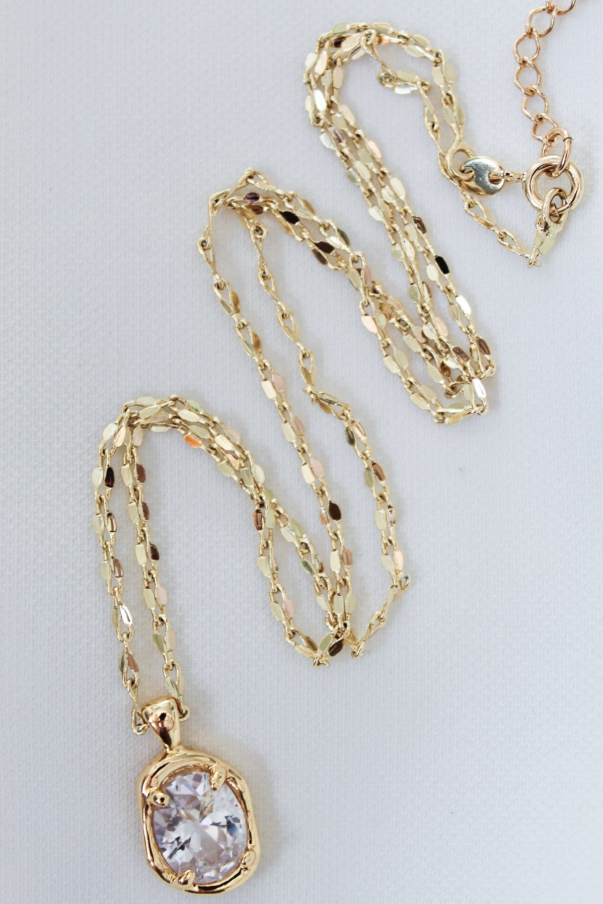 Kinsey Designs' Birdie Necklace features a clear cushion-cut CZ stone pendant on a gold-filled chain, shown against a white background.