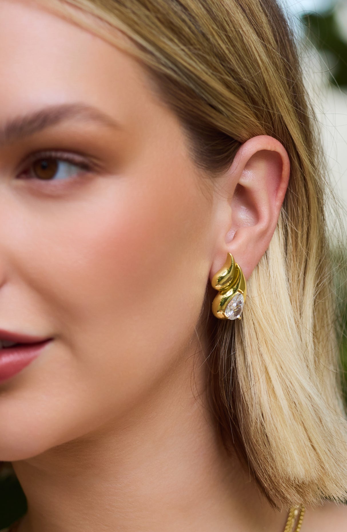 Close-up of a woman wearing the Kinsey Designs Archives Double Drop Stud—gold filled earrings featuring a teardrop gemstone, ideal for elevating your jewelry collection or finding at a sample sale.