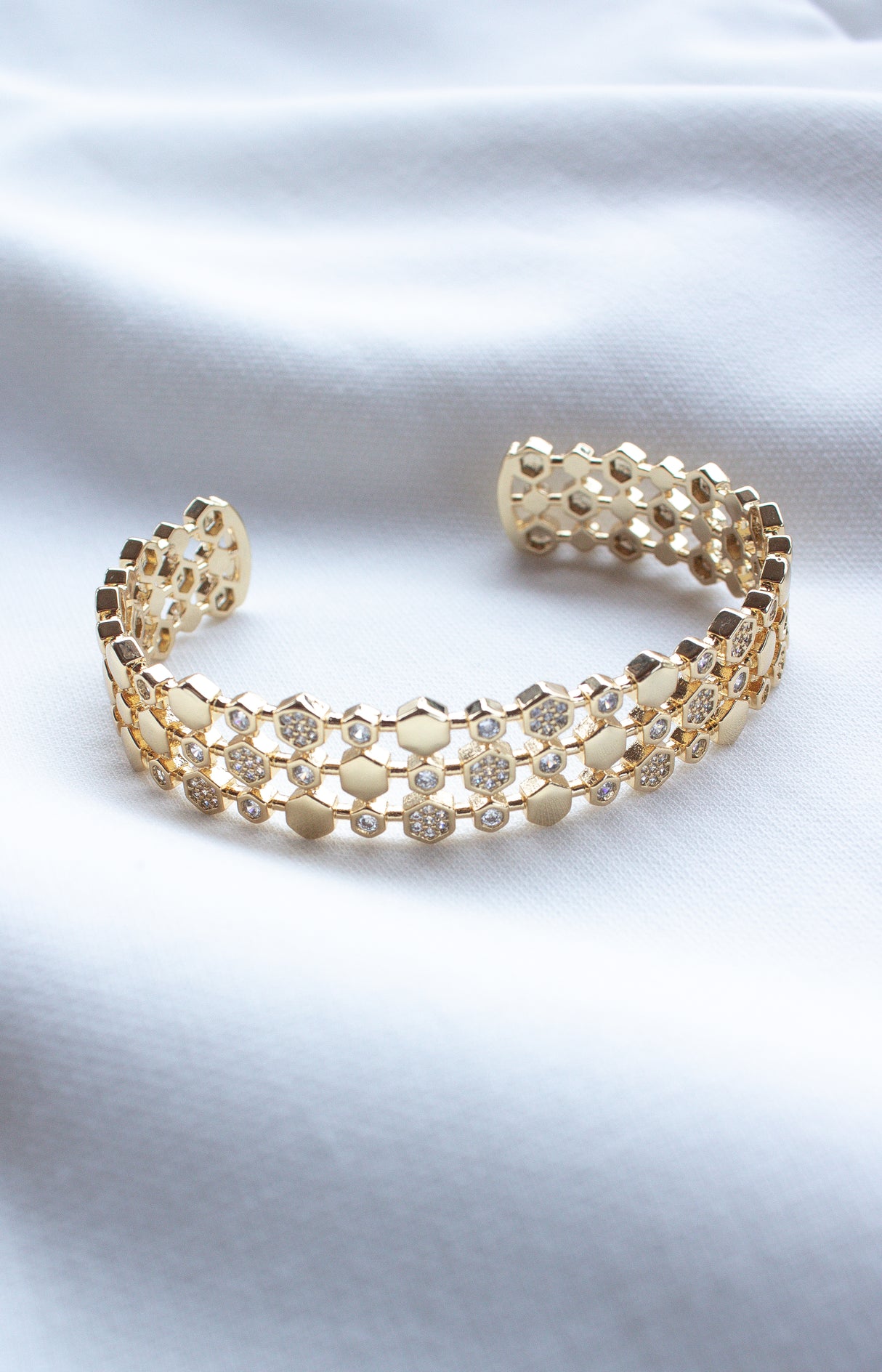 The Honey Cuff by Kinsey Designs Archives features hexagonal links and sparkling stones, displayed on soft white fabric. This gold-filled, adjustable bracelet adds elegance to any look. Shop our exclusive sample sale now!.