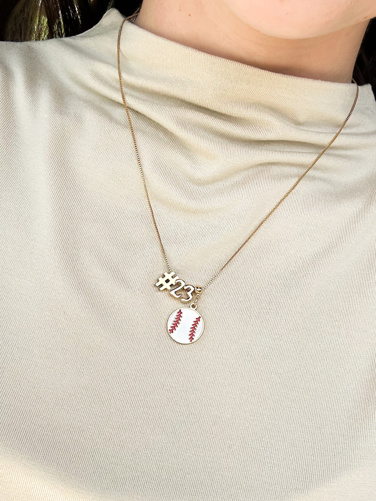Kinsey Designs Number Symbol Spacer Slide "#23" and a baseball slide charm necklace, styled over a cream-colored shirt.