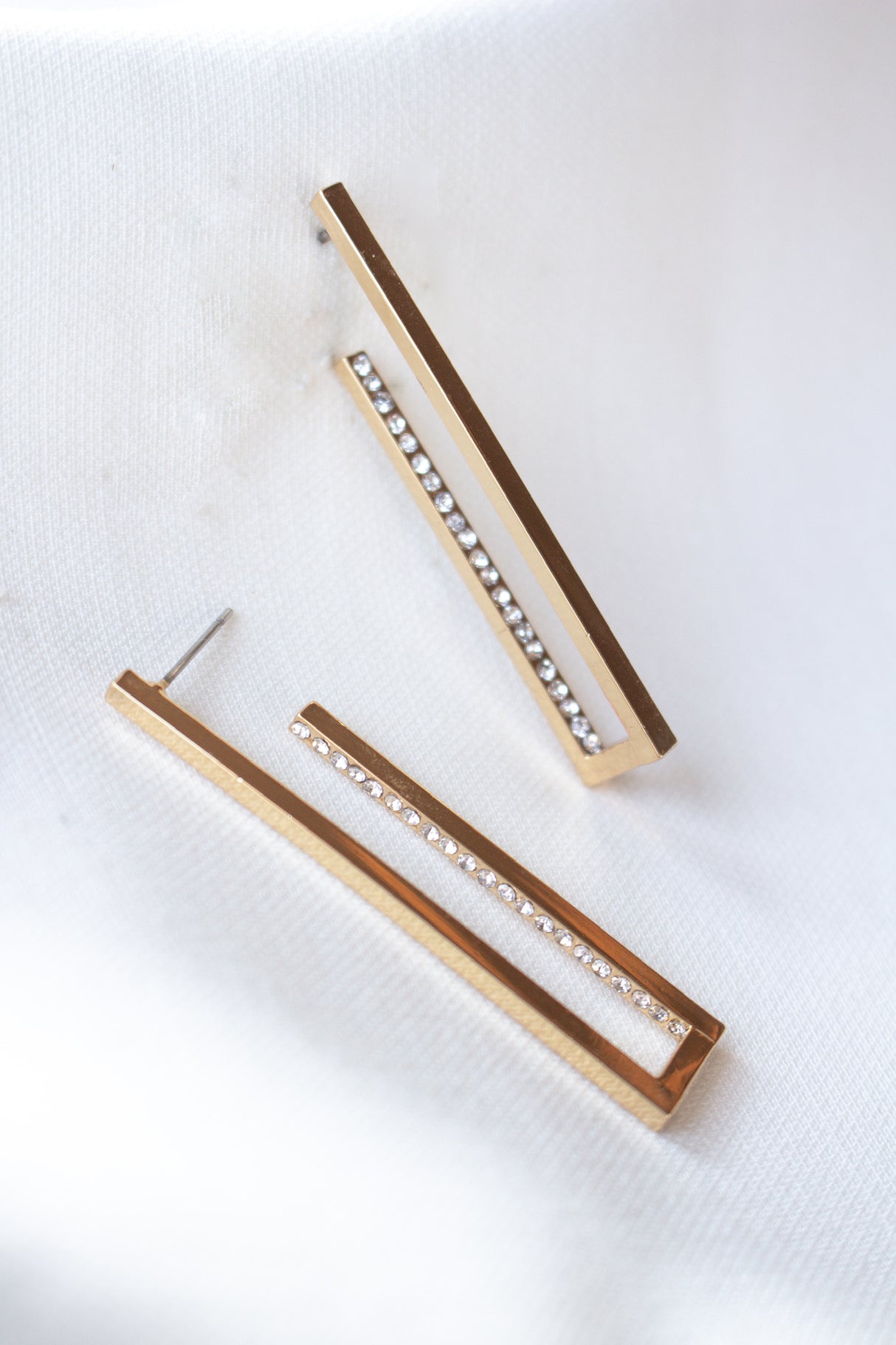 The Inside Job Hoop by Kinsey Designs Archives: rectangular gold-filled earrings with a row of cubic zirconia, showcased on white fabric. Enjoy elegant style at an exclusive sample sale price.
