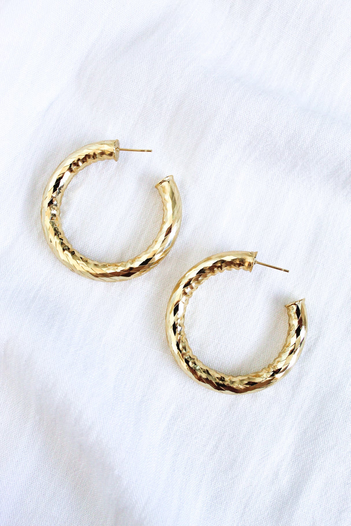 The Jasmine Hoops by Kinsey Designs are gold filled textured hoop earrings, shown on a white fabric background—perfect statement jewelry to elevate any look.