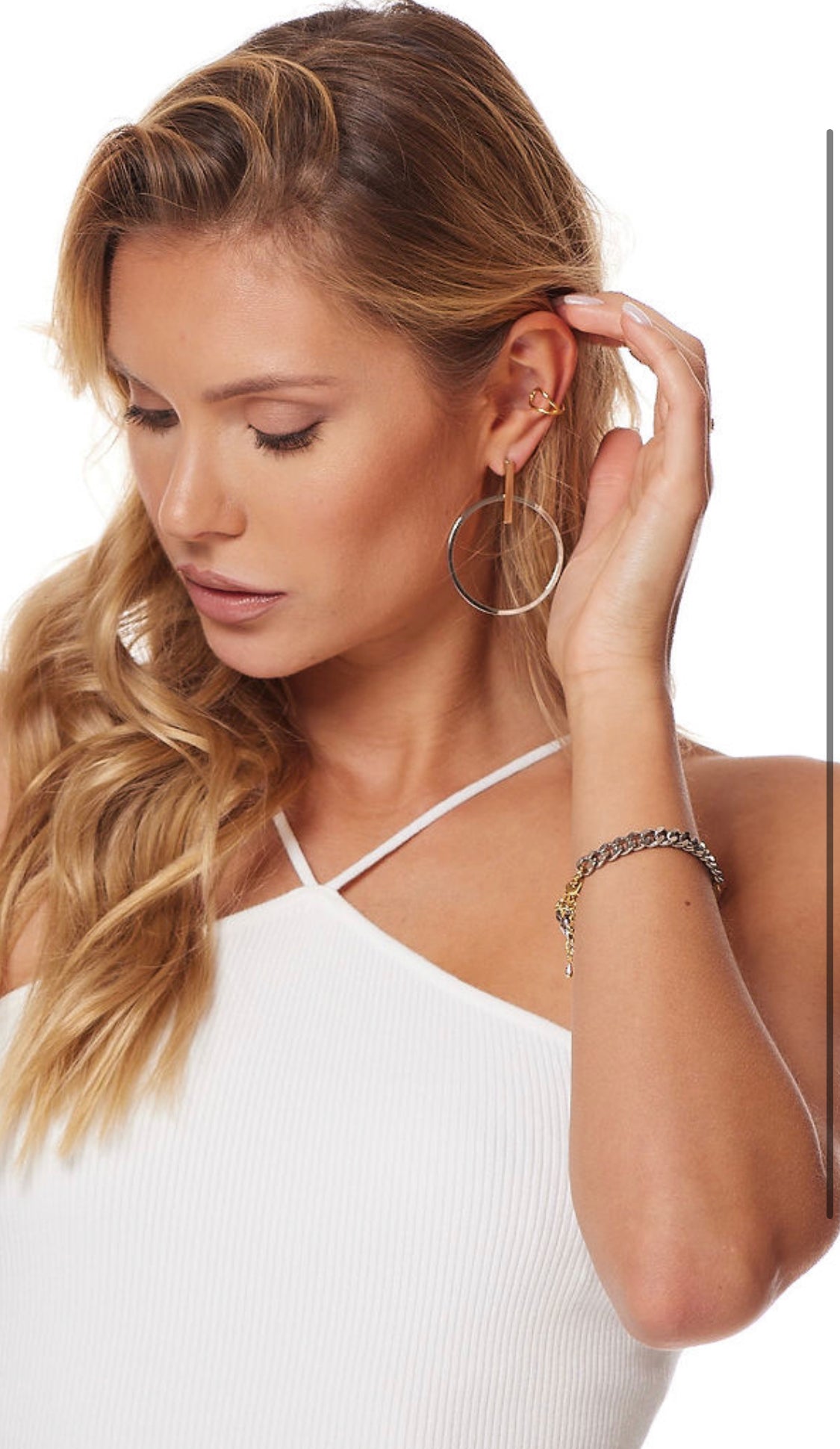 Woman in a white top touches her hair, wearing Kinsey Designs Archives' Josie Hoop earrings and a chain bracelet—perfect for your SAMPLE SALE look.