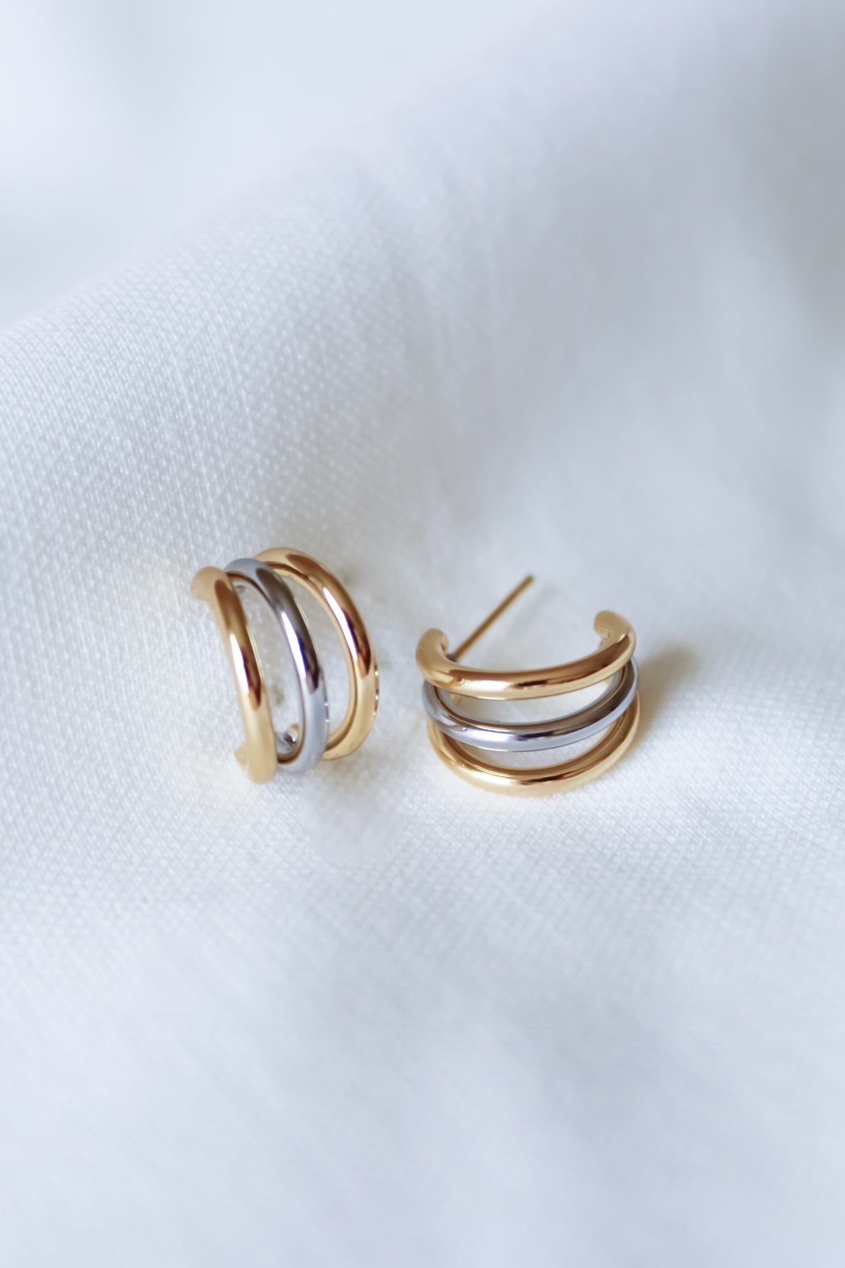 The Keera Mixed Earrings by Kinsey Designs feature triple-band gold and silver hoops, each with a .5" diameter, beautifully displayed on a soft white fabric background.