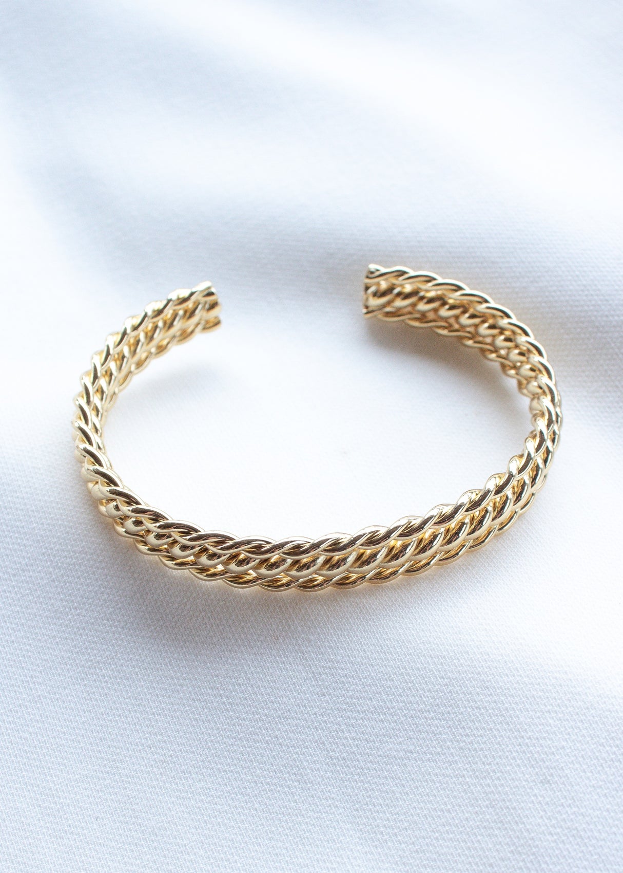 The Lenny Cuff by Kinsey Designs Archives is a gold filled twisted chain bracelet, adjustable for comfort and shown on white fabric—perfect for adding an elegant touch to any outfit.