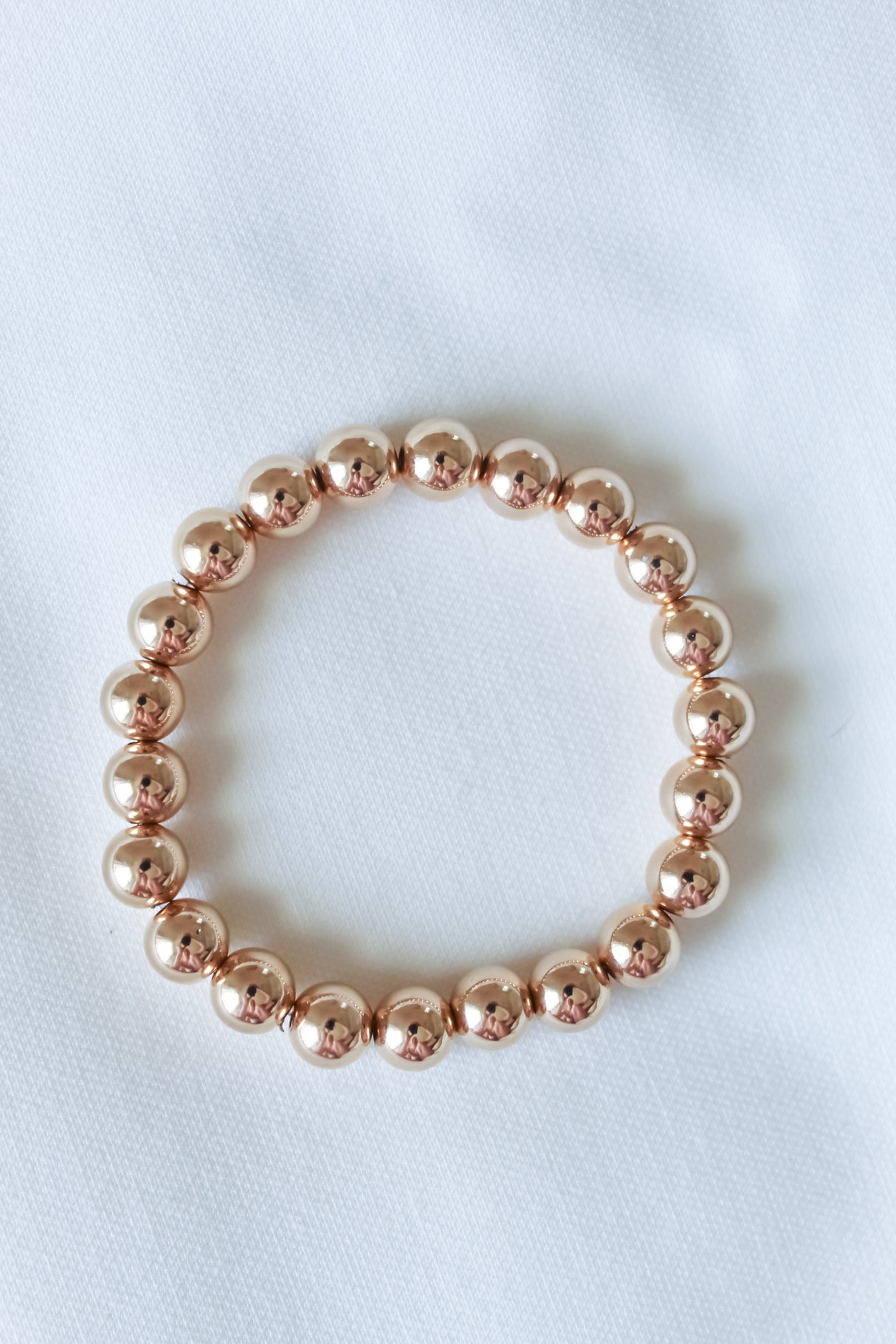 The Kinsey Designs Liam Stacking Bracelet, available in multiple sizes, is shown arranged in a circle on white fabric.
