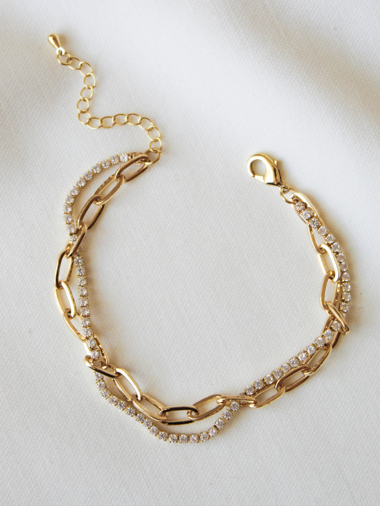 The Kinsey Designs Marc Tennis Bracelet features a single strand of rhinestones set in gold fill, shown against a white fabric background.