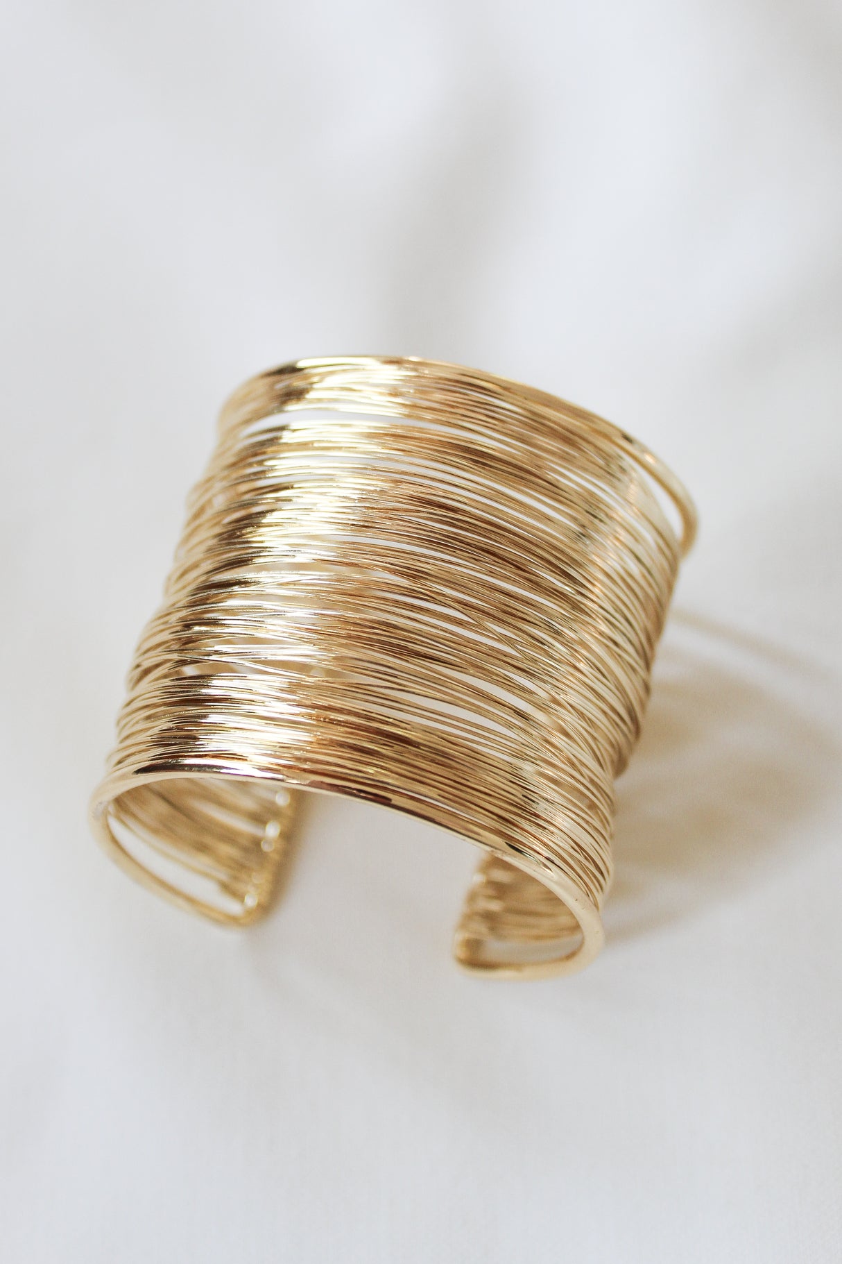 The Mesheyl Cuff by Kinsey Designs features multiple thin, textured gold-filled wires for a bold look—ideal to pair with your favorite earrings or find at our sample sale. Displayed on a white background.
