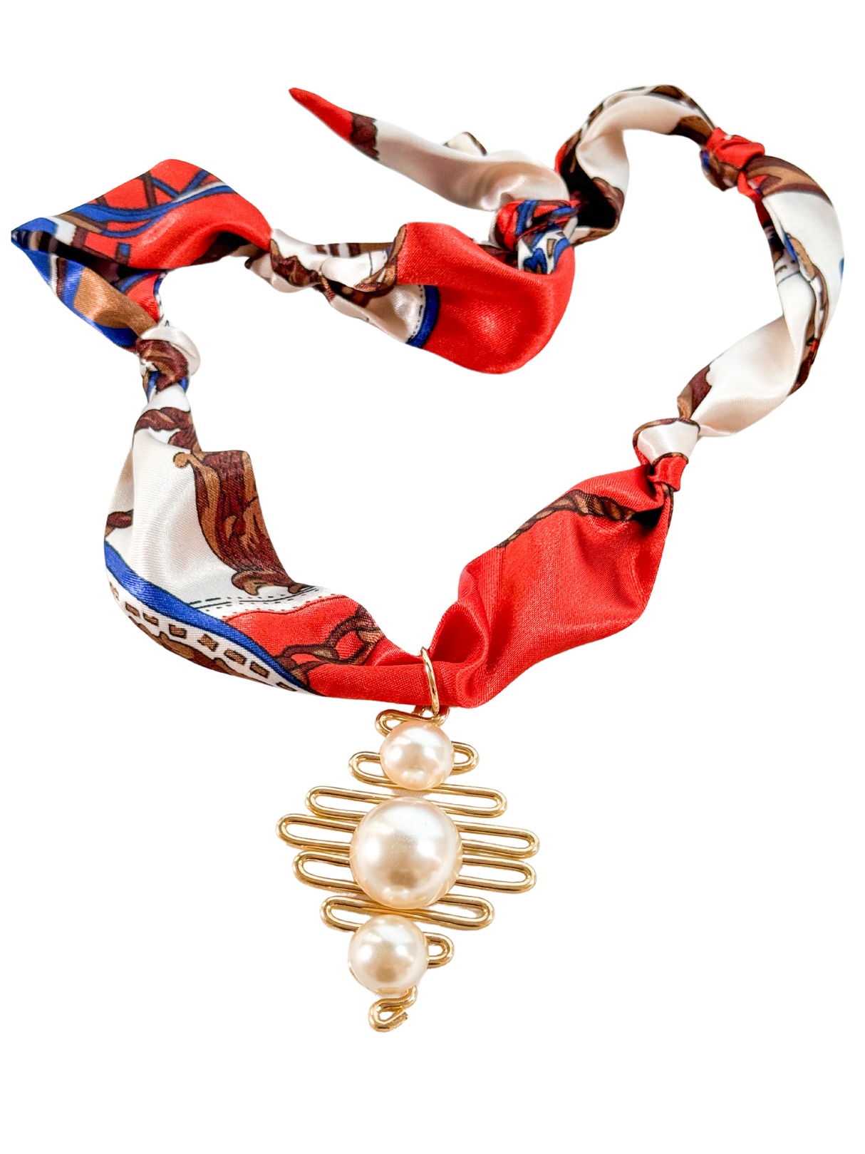 The Naples Scarf Necklace by Kinsey Designs features a gold wire pendant with three pearls on a red, white, and blue silk scarf. Adjustable and stylish, it adds elegant flair to any outfit.