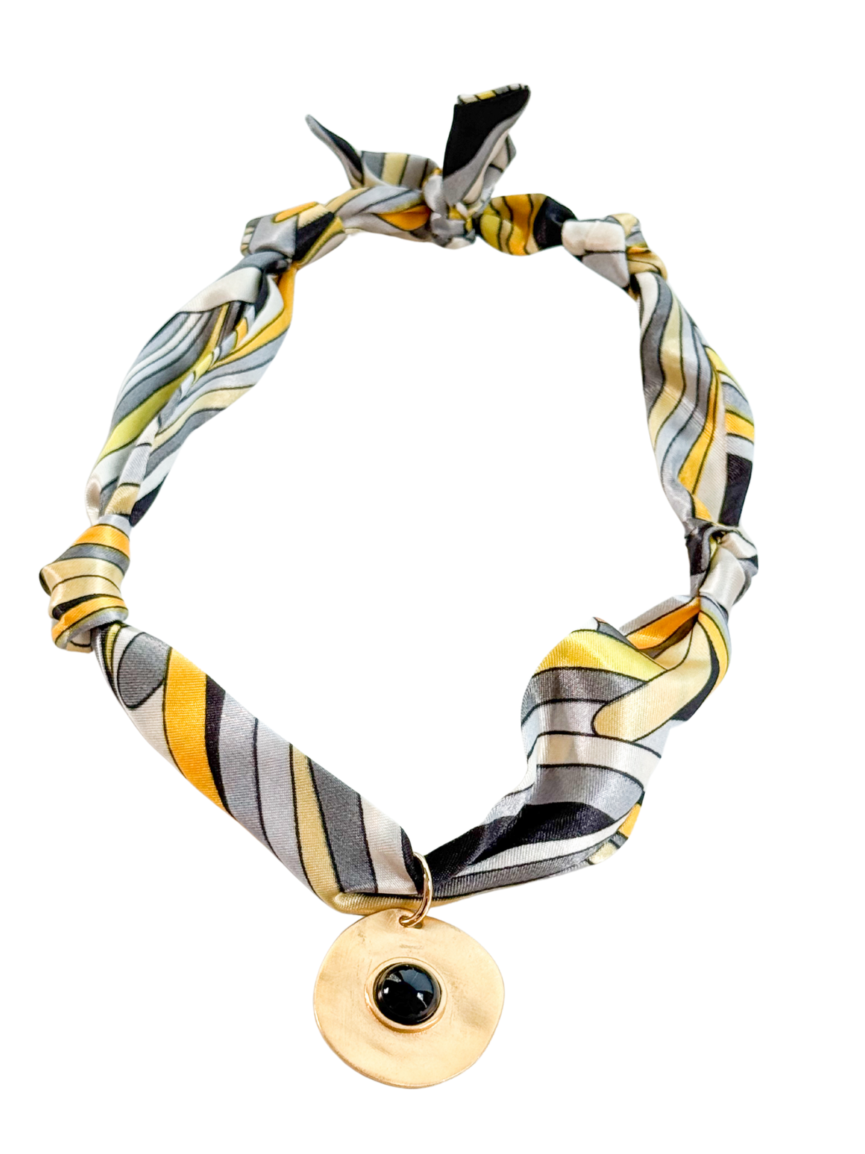 The Parma Scarf Necklace by Kinsey Designs showcases yellow, gray, and black stripes with a vintage-inspired round gold pendant accented by a bold black stone.