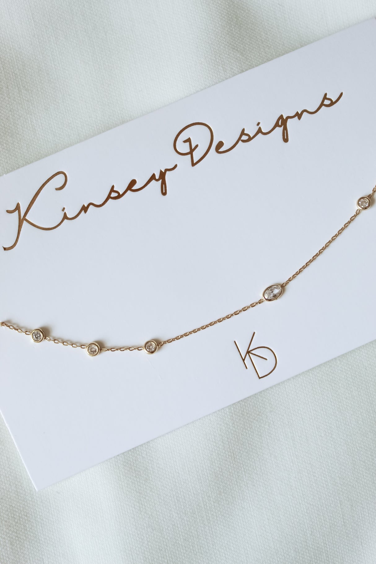 Elegant Pozey Necklace by Kinsey Designs, displayed on a white fabric background—ideal for gifting or layering. SAMPLE SALE—don't miss your chance!.