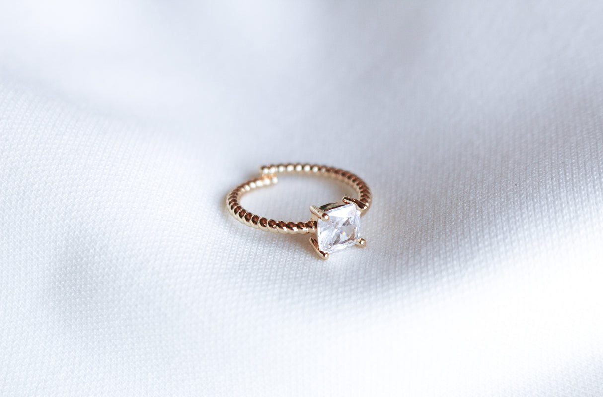 The Rose Ring - Sale by Kinsey Designs Archives features a square-cut cubic zirconia, elegantly displayed on a white fabric background.