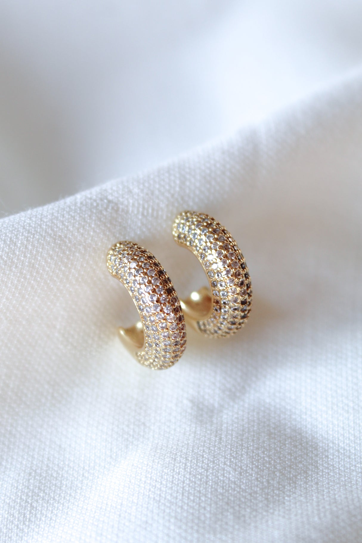 Kinsey Designs' Sax Hoop gold filled earrings, .85" diameter, feature small gemstones and are shown on a white fabric background.