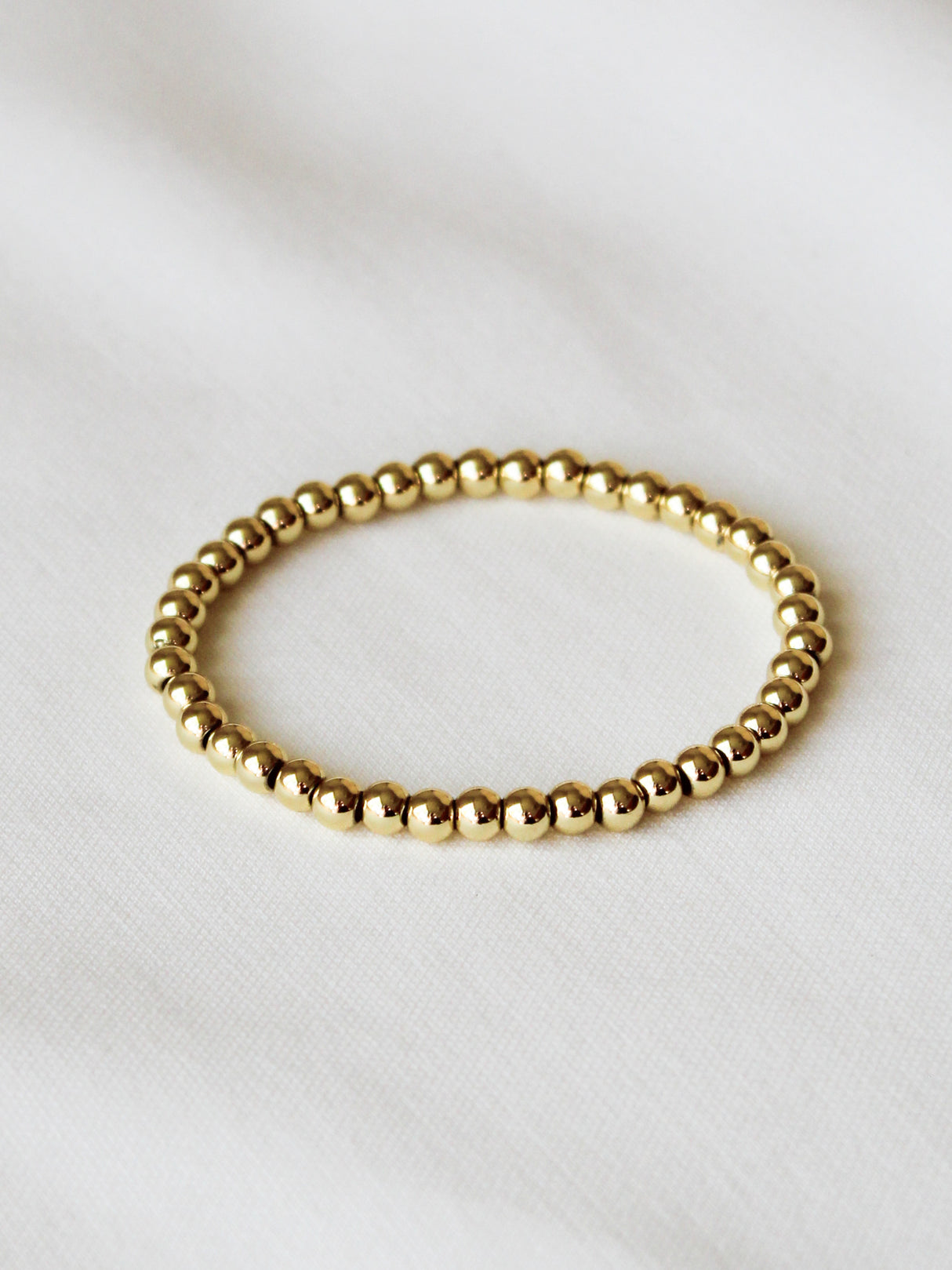 The Kinsey Designs Stretch Bead Bracelet 5MM is displayed flat on white fabric, highlighting its elegant beaded design.