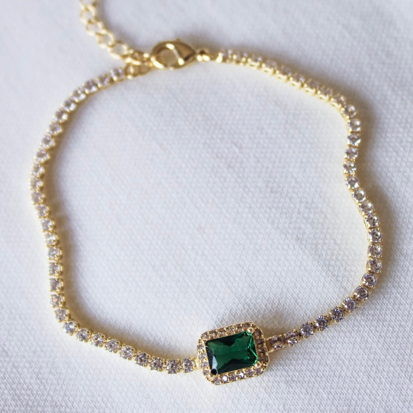 The Kinsey Designs Archives Lara Bracelet – Emerald features a gold filled chain, sparkling cubic zirconia, and a rectangular green gemstone centerpiece. Measures 8 inches for a comfortable fit. Displayed on a white background.