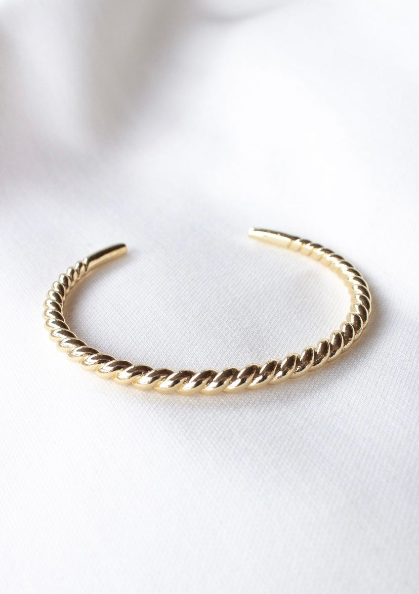 The Kinsey Designs Fallon Mama & Baby Cuff Set features an adjustable, nickel-free, gold-filled twisted open cuff—ideal for daily wear. Shown on white fabric.