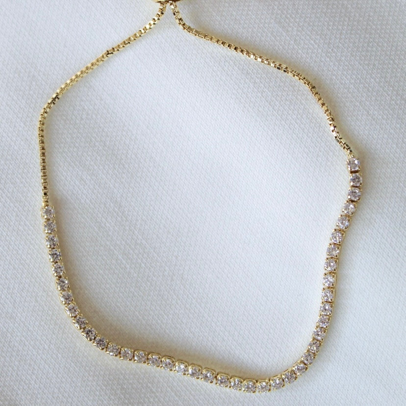 Katie Bracelet by Kinsey Designs featuring clear round cubic zirconia stones is displayed on a white textured fabric background.