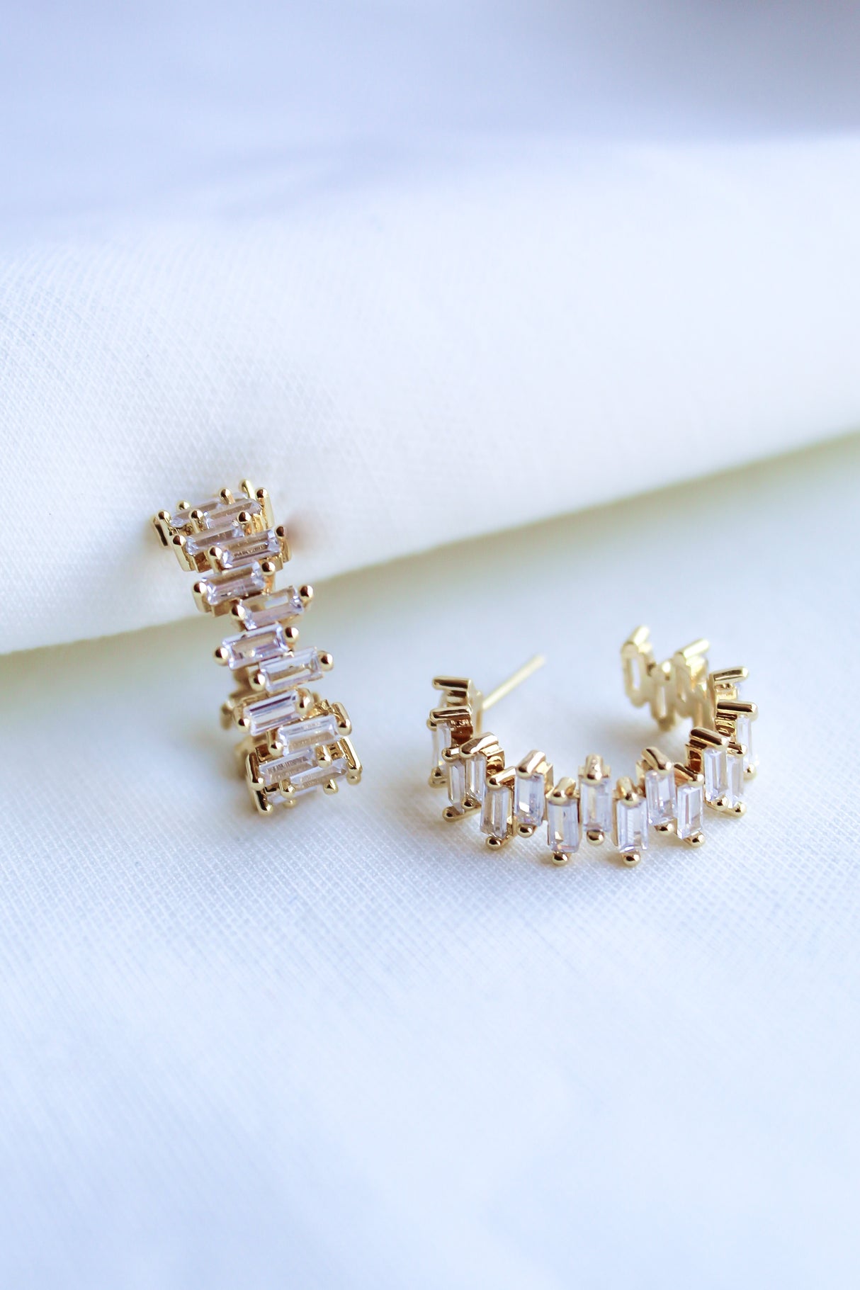 The Ettie Hoop by Kinsey Designs Archives is a pair of gold filled earrings with 1" diameter, featuring rectangular cubic zirconia stones in a row, shown on a white fabric background.