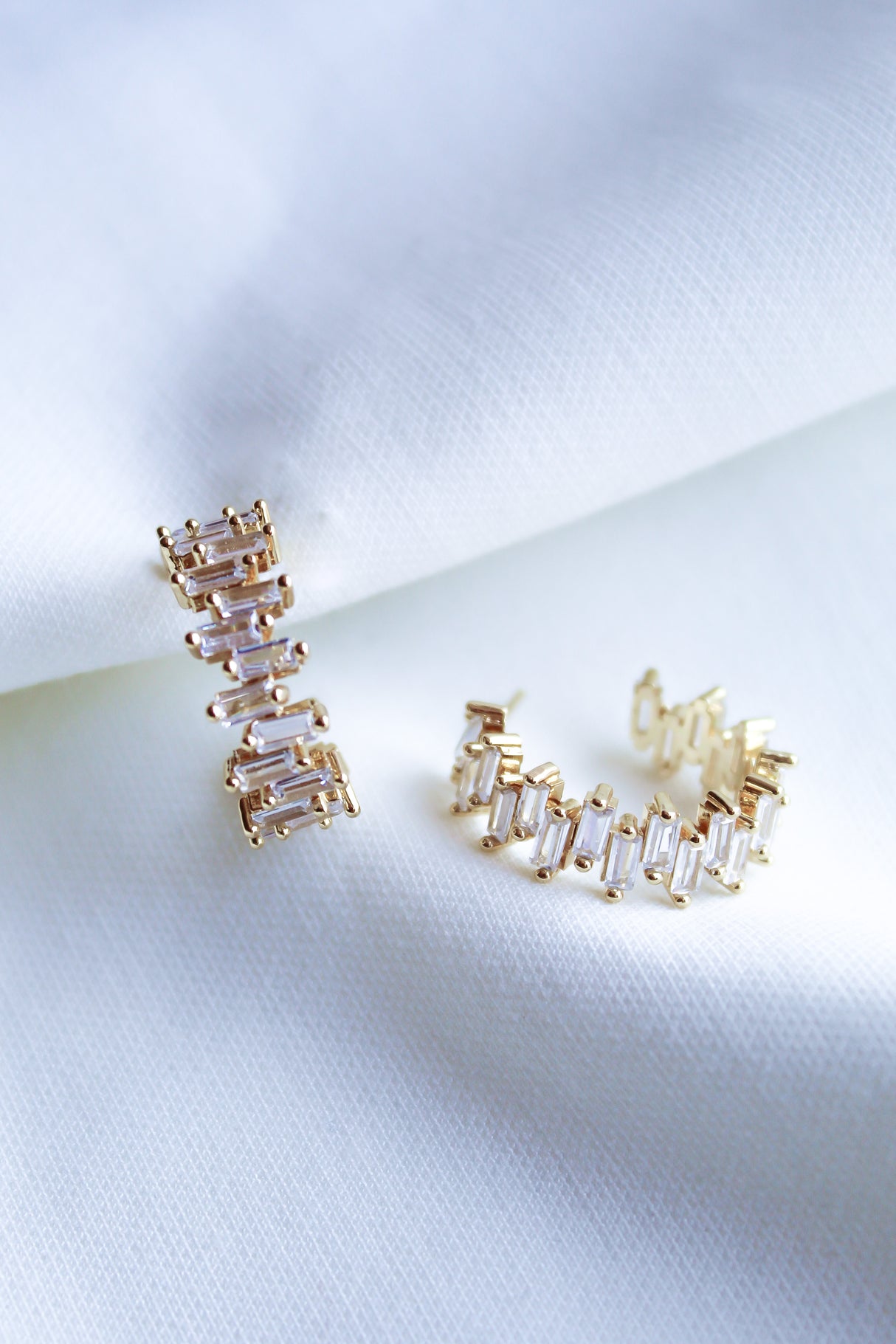 The Ettie Hoop by Kinsey Designs Archives features 1" gold filled earrings with rectangular cubic zirconia stones in a row, shown on white textured fabric.
