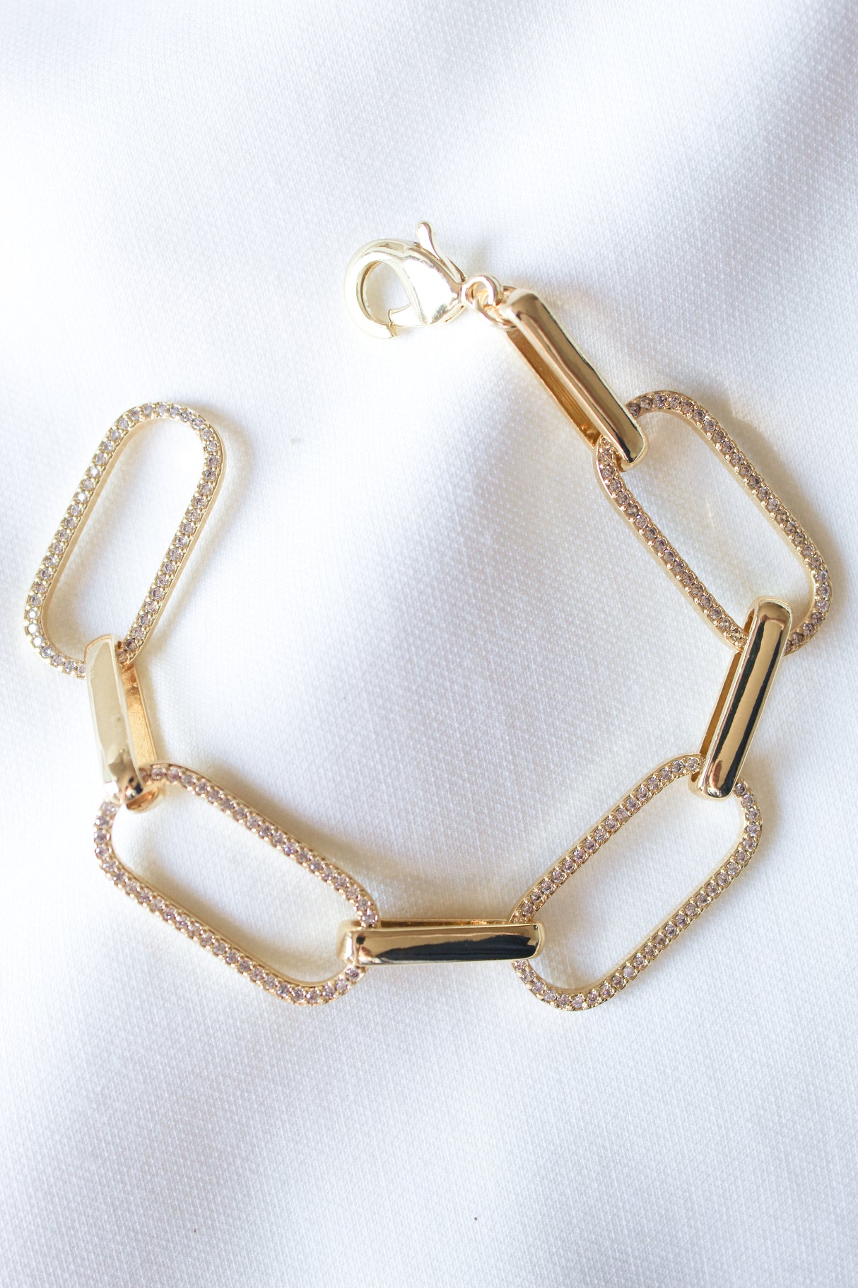 The Jameson Bracelet by Kinsey Designs, featuring rectangular links, is shown on a white fabric background.