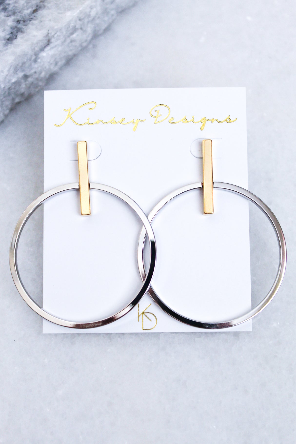 Jocelyn - Mixed Metals gold plated hoop earrings, 2” wide by 2.5” long, from Kinsey Designs Archives, shown on a white display card.