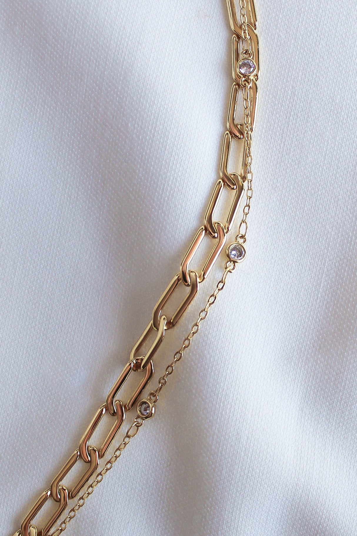 The Lisbon Bracelet by Kinsey Designs Archives rests elegantly on a white fabric background, showcasing its delicate design and sparkling details.