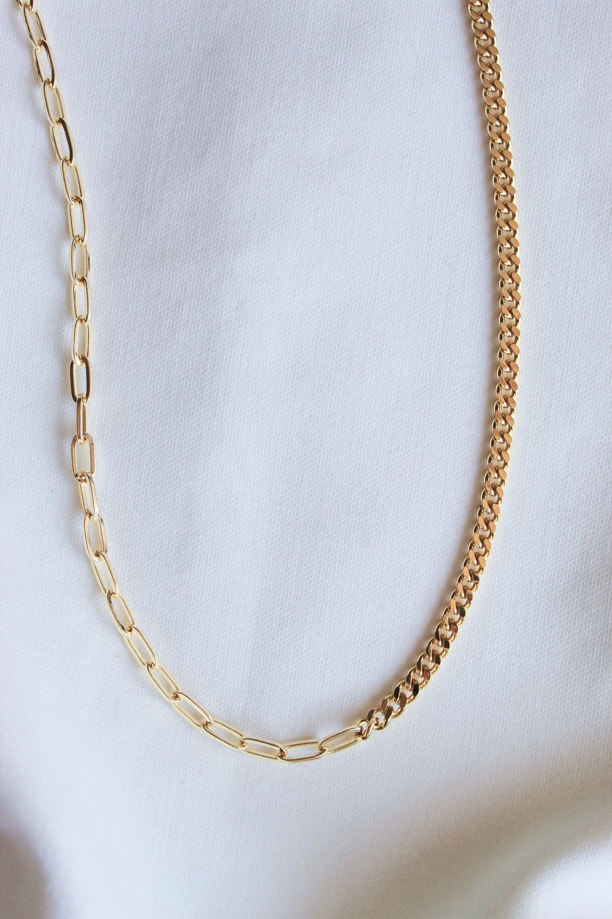 The Saxon Necklace by Kinsey Designs Archives features two bold gold-filled chain styles, elegantly displayed on a white fabric background.