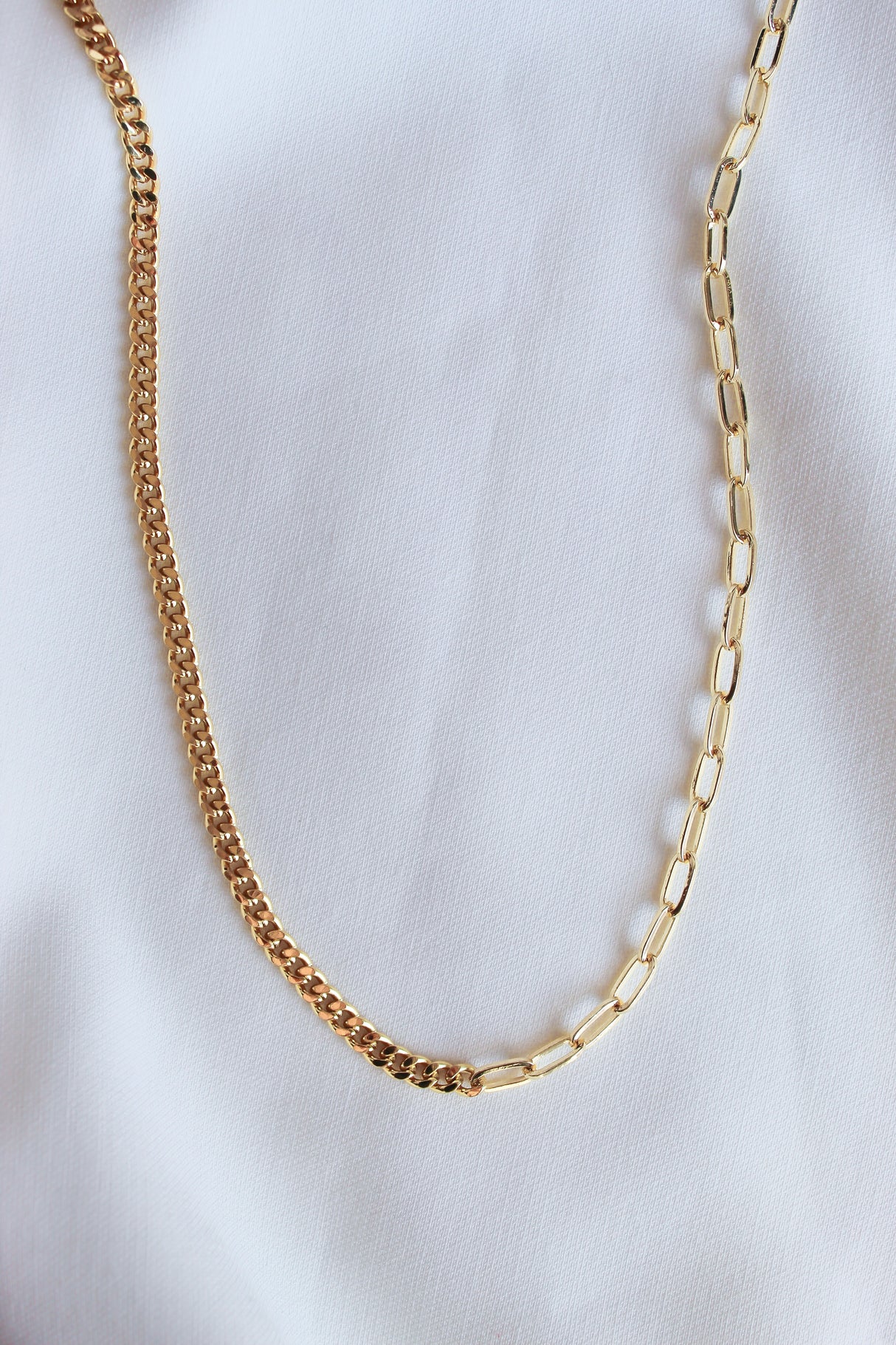 The Saxon Necklace by Kinsey Designs Archives features bold gold-filled mixed links, making a statement chain displayed on a white fabric background.