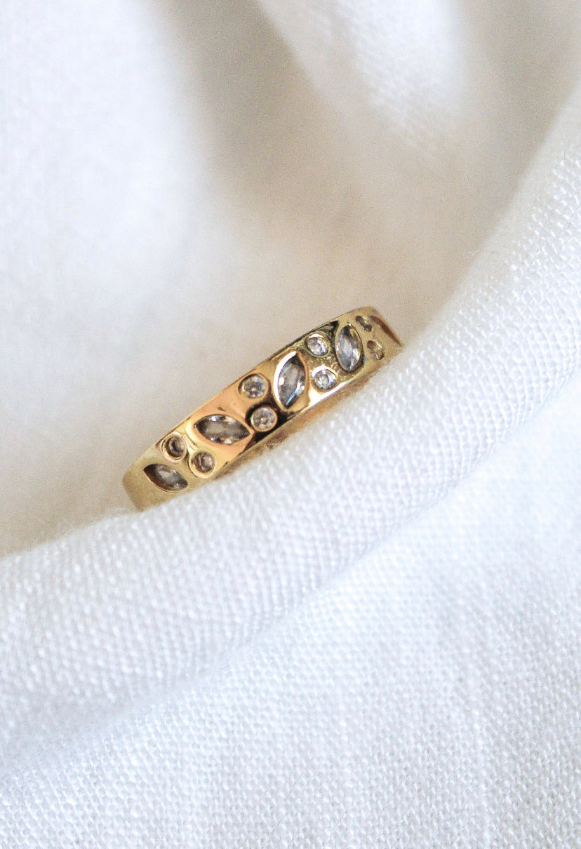 The Luna Ring - Multi by Kinsey Designs Archives, featuring gold plating with leaf and diamond details in size 7, is displayed on soft white fabric.