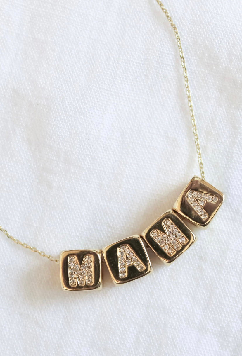 The Kinsey Designs MAMA Block Necklace features four square letter charms spelling "MAMA"—a stylish and thoughtful Mother's Day gift.