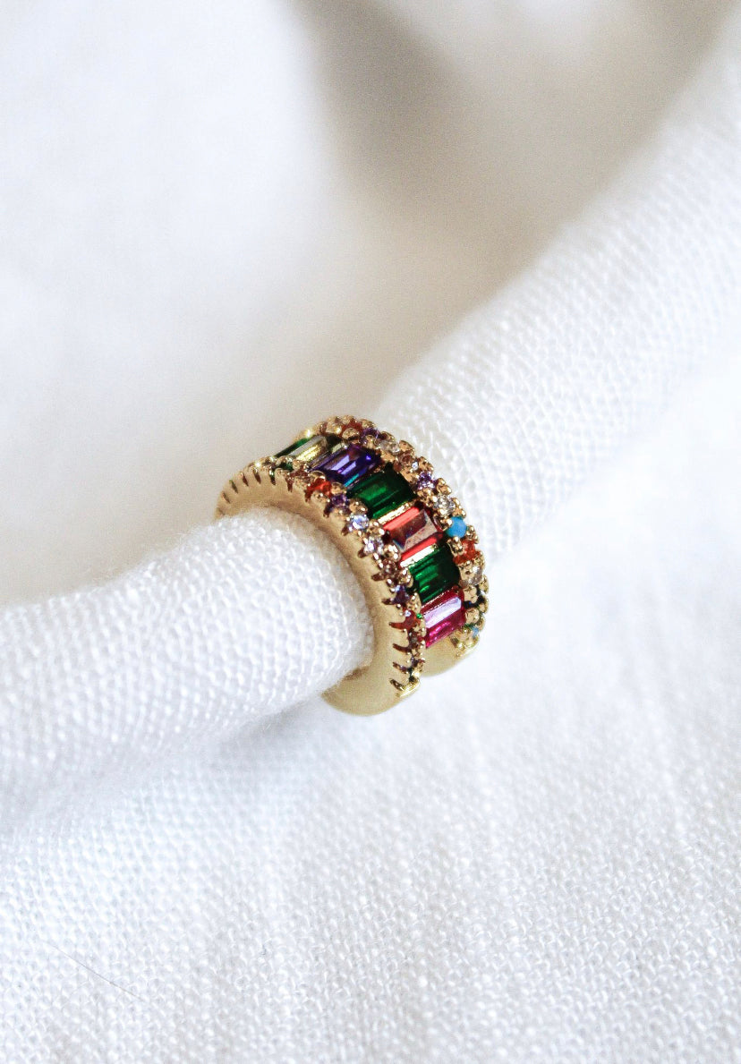 Clementine Ear Cuff by Kinsey Designs Archives featuring colorful baguette gemstones and sparkling cubic zirconia, shown on white textured fabric. SAMPLE SALE.