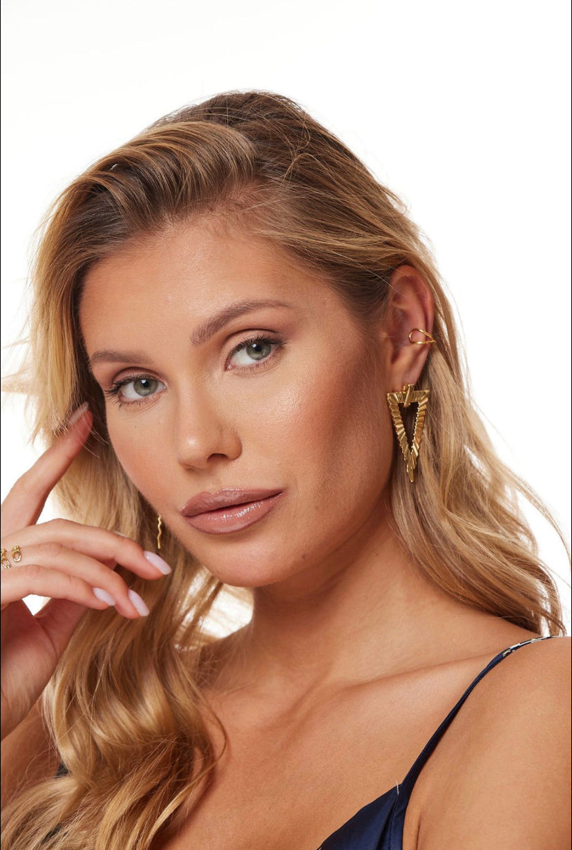 Woman with long blonde hair wears the Colin Earring by Kinsey Designs and a navy top, posing with her hand near her face.