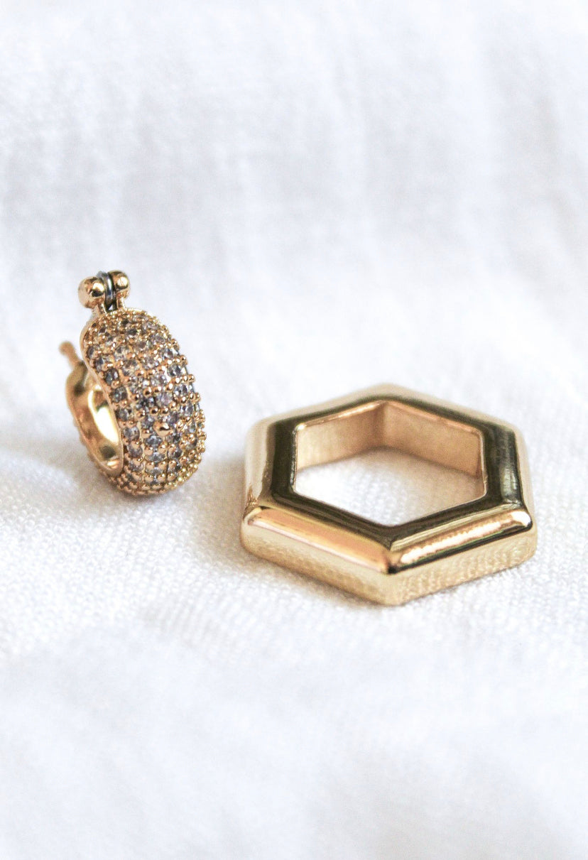 The Stevie 2-Way Hoop by Kinsey Designs Archives features gold plating, sparkling cubic zirconia, and a removable hexagon pendant, shown on a white fabric background.