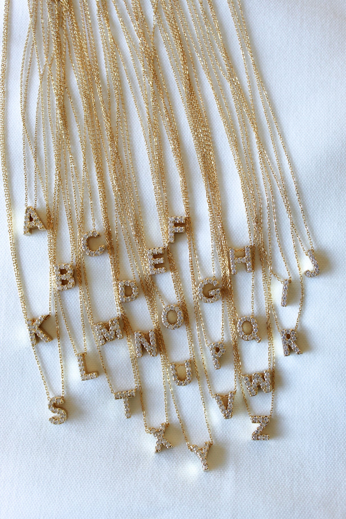 The Kinsey Designs Collection LUX Slide Initial Necklace features a sparkling letter G pendant displayed on a white surface.