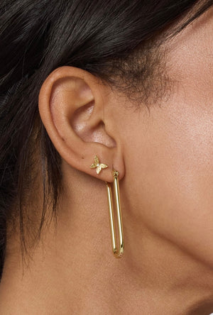 Close-up of an ear wearing a small butterfly stud and the Tate Hoop by Kinsey Designs Archives, a large gold filled earring perfect for adding glam to your look.