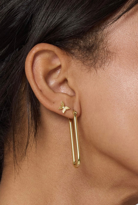 Close-up of an ear wearing a small butterfly stud and the Tate Hoop by Kinsey Designs Archives, a large gold filled earring perfect for adding glam to your look.