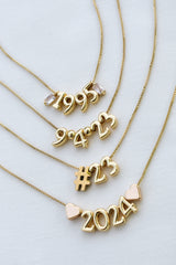 Five Numerical Slide - Kinsey Charm Bar gold-filled necklaces with slides reading "1995," "9-4-23," "23," "#23," and "2024" displayed on a white background.