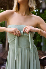 A woman wearing the Mia Bracelet by Kinsey Designs stands outdoors with lush greenery behind her.