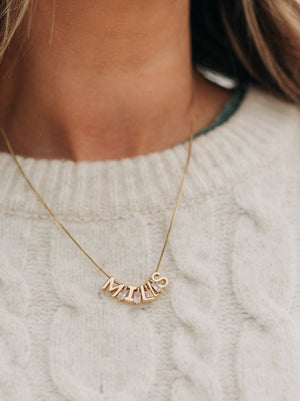 Kinsey Designs' Stone Spacer Slide necklace in your choice of 9 colors, styled here over a cream cable knit sweater.