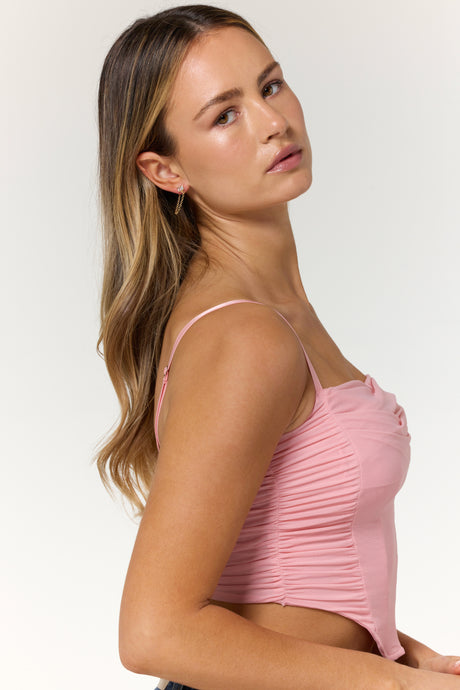 Woman with long brown hair wearing a pink ruched tank top and Kinsey Designs Archives' Astrid Earrings, posing against a light background.