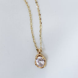 Kinsey Designs Birdie Necklace features a round, clear gemstone pendant on a delicate gold filled chain, shown against a white background.