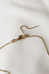 A delicate Charm Bar Necklace Box Chain - Kinsey Charm Bar, set on a white fabric background, featuring a lobster clasp and an adjustable extension chain.