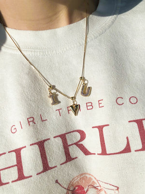 Kinsey Designs Collection’s Bubble Letter Grip Charm Letter A adds style to a white sweatshirt with red text.
