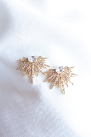 Kinsey Designs' Elaine Post earrings feature gold-filled radiating spikes and central cubic zirconia gemstones, shown on a white fabric background.
